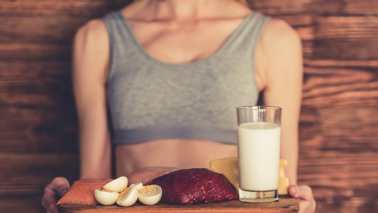 Mulher segurando alimentos proteicos