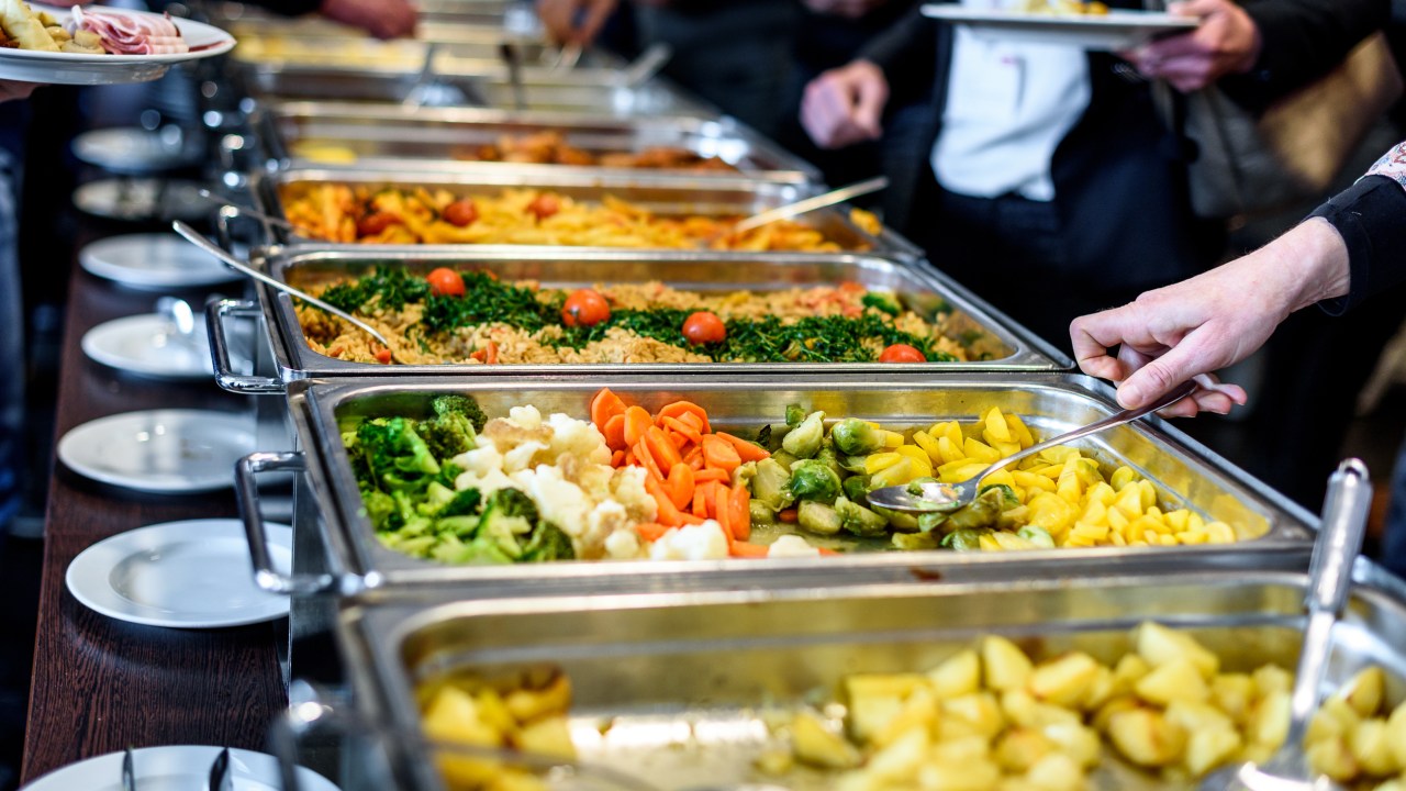 Pessoa pegando comida em buffet