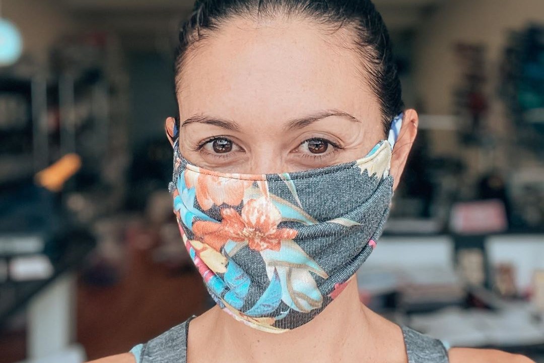 mulher usando máscara de proteção contra coronavírus feita de tecido florido