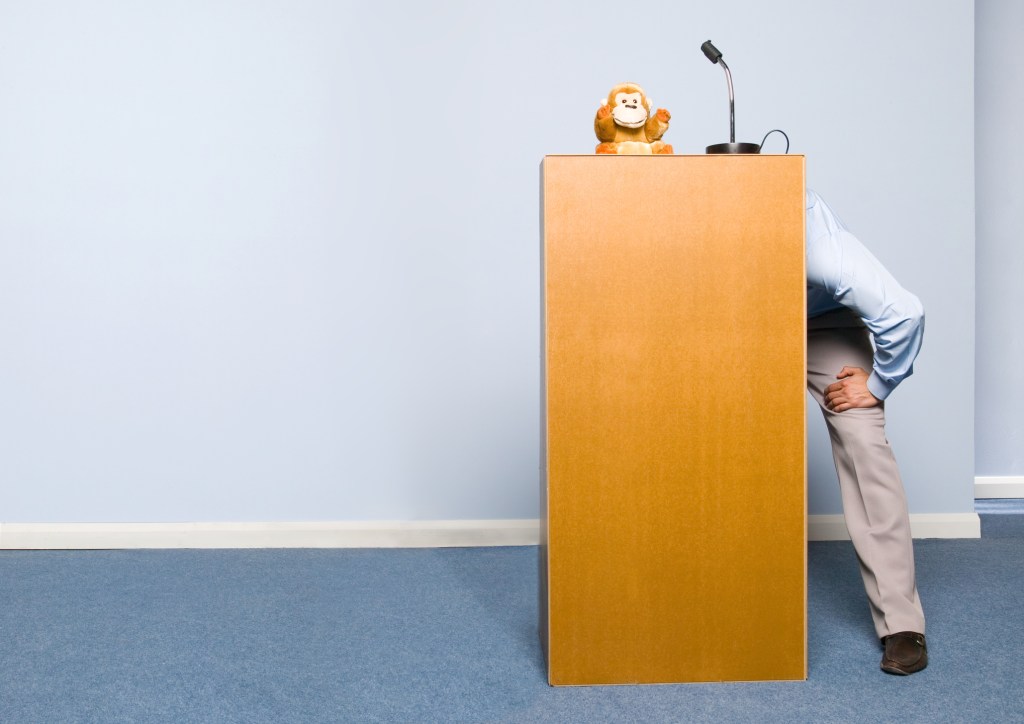 Businessman Giving Puppet Show on Podium -