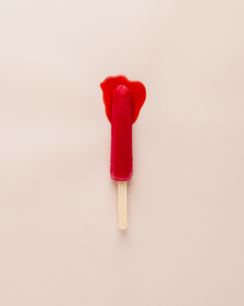 o que é endometriose picolé vermelho derretendo em fundo rosa