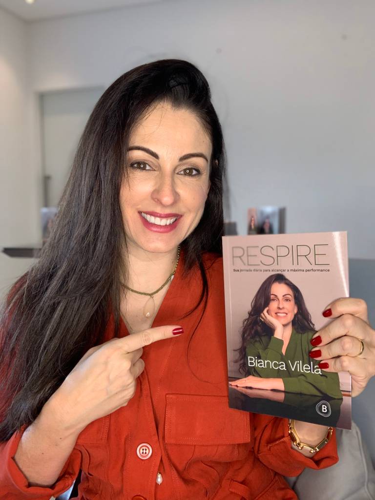 Bianca Vilela segurando seu novo livro 