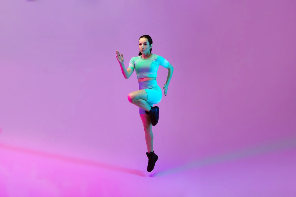 Young sportive woman training isolated on gradient studio background in neon light. athletic and graceful. Modern sport, action, motion, youth concept. Beautiful caucasian woman practicing. Young sportive woman training isolated on gradient studio background in neon light. athletic and graceful. Modern sport, action, motion, youth concept. Beautiful caucasian woman practicing.