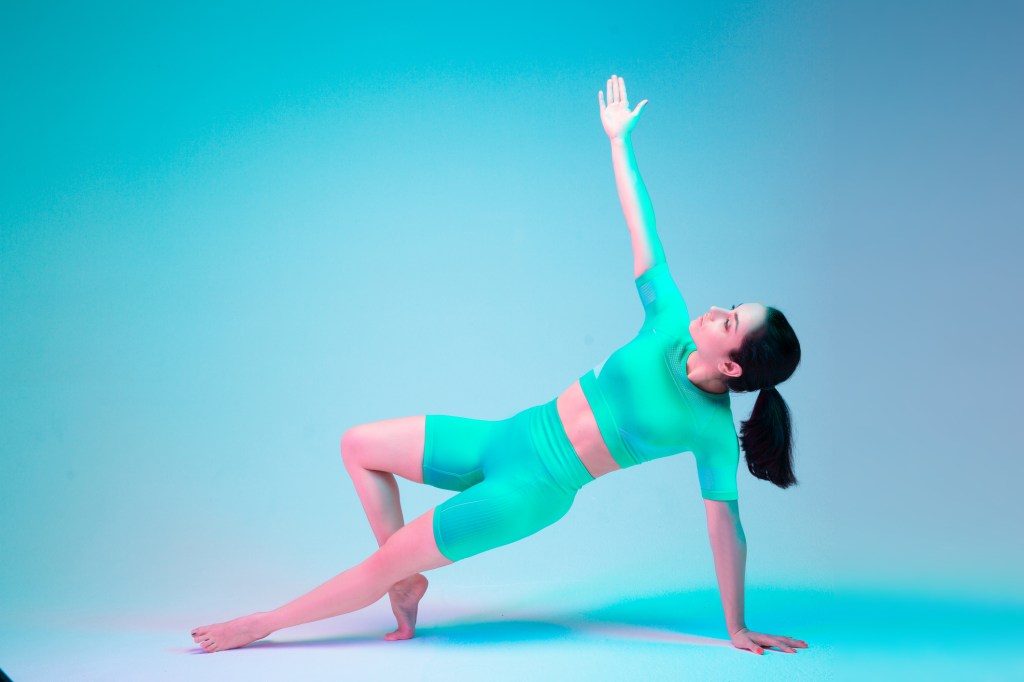 Plank. Young sportive woman training isolated on gradient studio background in neon light. athletic and graceful. Modern sport, action, motion, youth concept. Beautiful caucasian woman practicing. emom