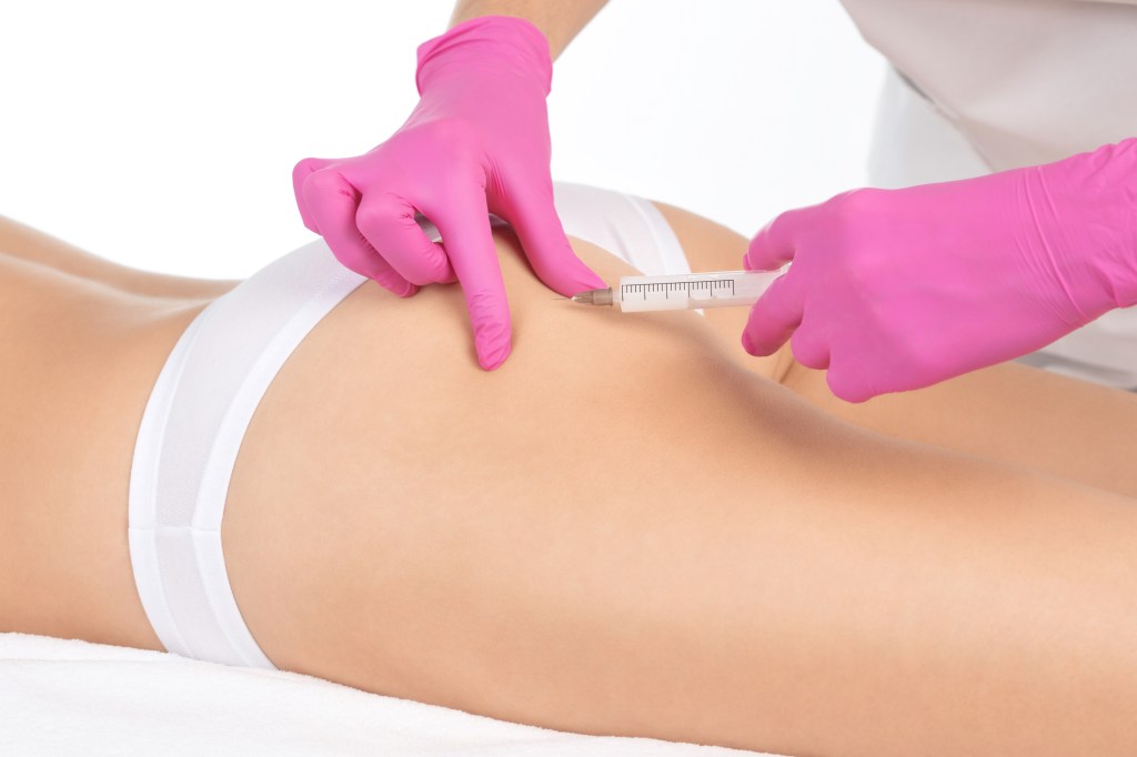 Aesthetic cosmetologist makes lipolytic injections to burn fat on the thighs, hips and body of a woman. Female aesthetic cosmetology in a beauty salon.Cosmetology concept. bumbum care