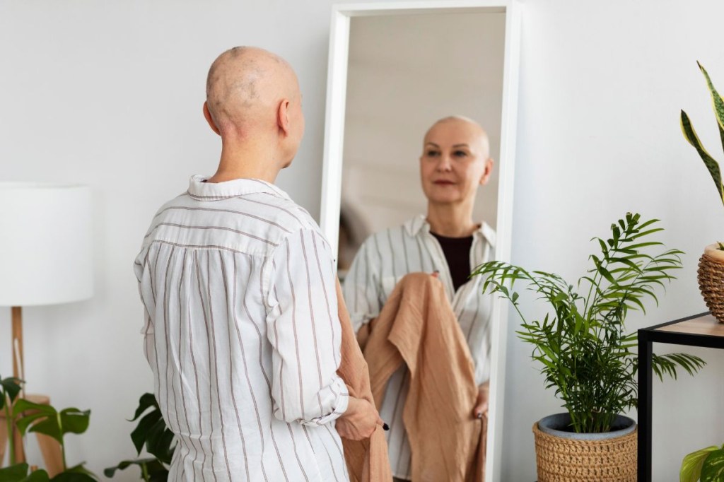 autoestima Mulher careca se olhando no espelho
