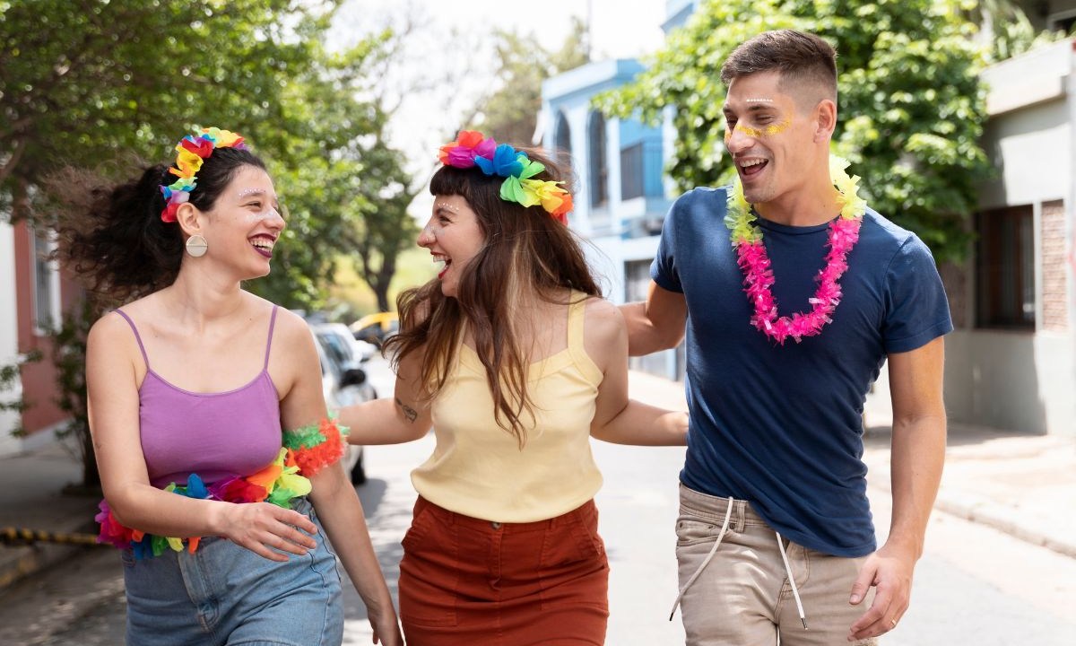 Pessoas fantasiadas com adereços coloridos andando pela rua